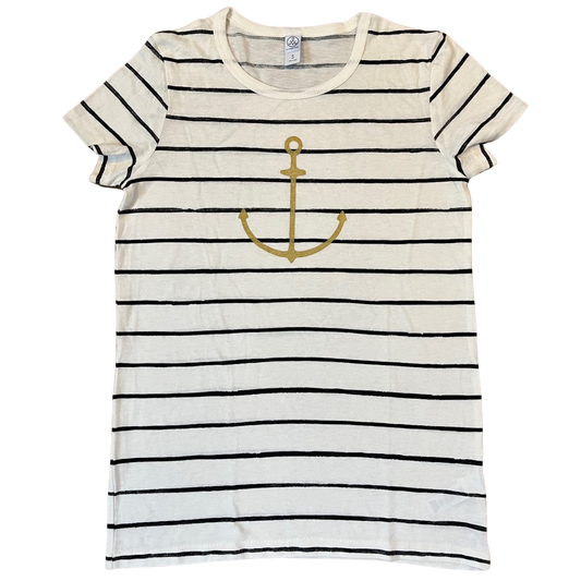 Flat lay of white and black striped t-shirt with a small gold anchor graphic on the chest, displayed on a clean white background