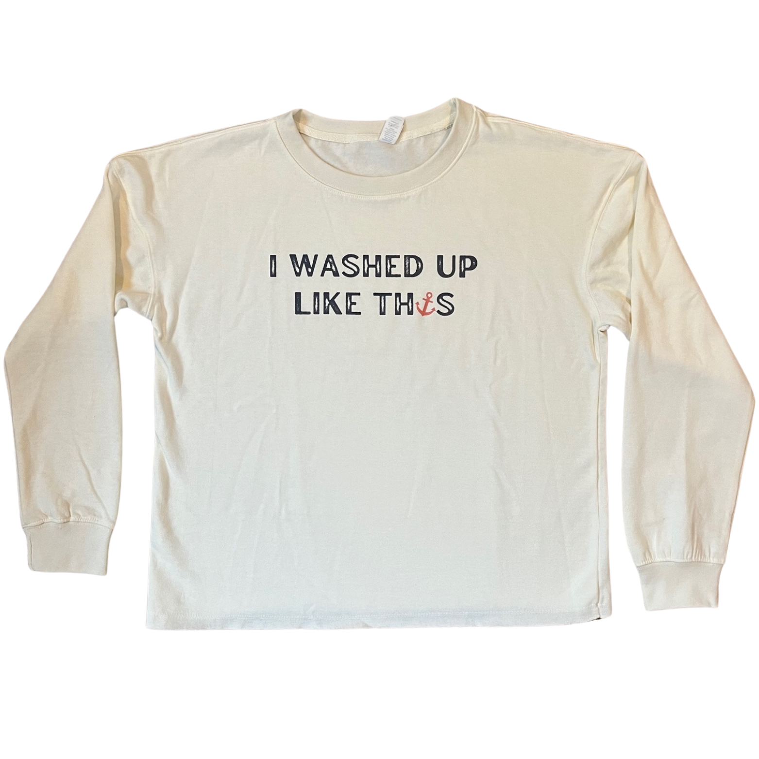 Flat lay of I Washed Up Like This beach fleece sweatshirt in soft bleached linen color with playful coastal text design, shown neatly folded