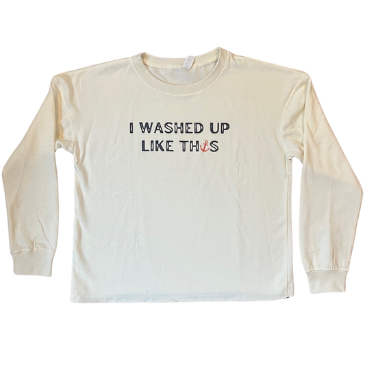 Flat lay of I Washed Up Like This beach fleece sweatshirt in soft bleached linen color with playful coastal text design, shown neatly folded