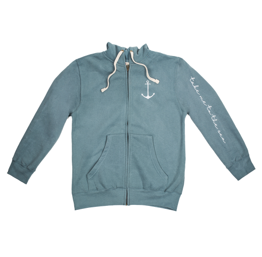 Marine blue heavyweight zip hoodie with anchor chest graphic and 'take me to the sea' sleeve print, laid flat to show sueded finish and classic fit.