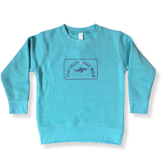 Layflat view of Coral Anchor's toddler crewneck sweatshirt in saltwater blue with shark graphic and "Stay Salty, Stay Wild" text