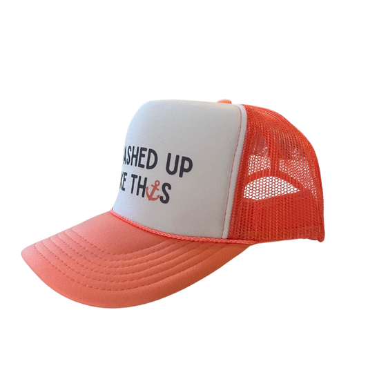 Side view of coral and white trucker hat with mesh back and curved bill, featuring “I Washed Up Like This” graphic on the front.